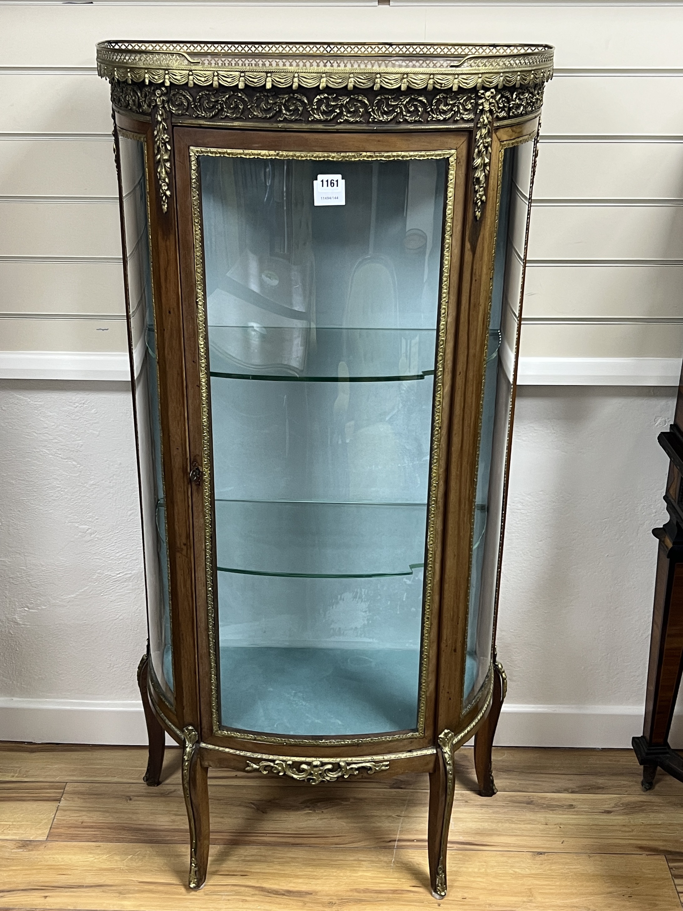 A French gilt metal mounted marble topped bow front vitrine, width 66cm, depth 32cm, height 140cm